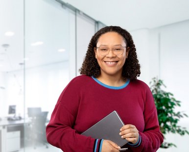 Eine Frau hält in einem Büro ein Tablet-Computer.