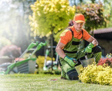 Ein Mann in Arbeitsuniform arbeitet im Garten.