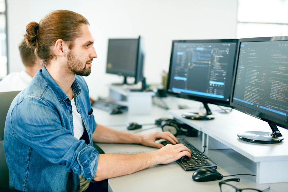 Ein Mann sitzt am Computer und arbeitet.