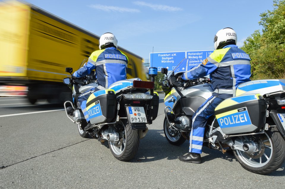 Zwei Polizisten auf einem Motorrad der Polizei.