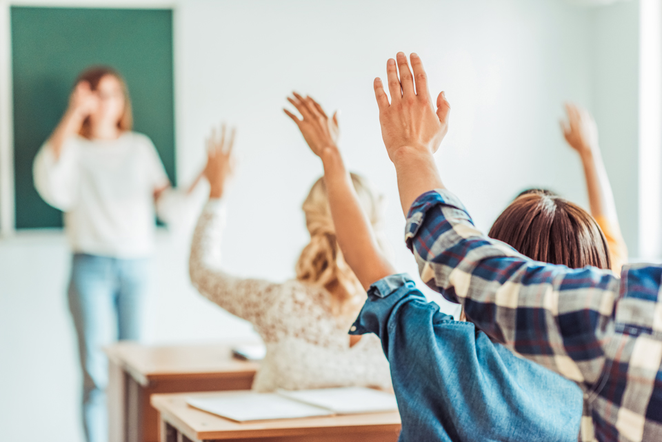 Viele Personen melden sich innerhalb eines Klassenzimmers.