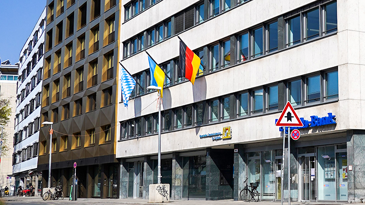 Bürogebäude mit Deutschland-, Bayern- und Ukraine-Flagge.